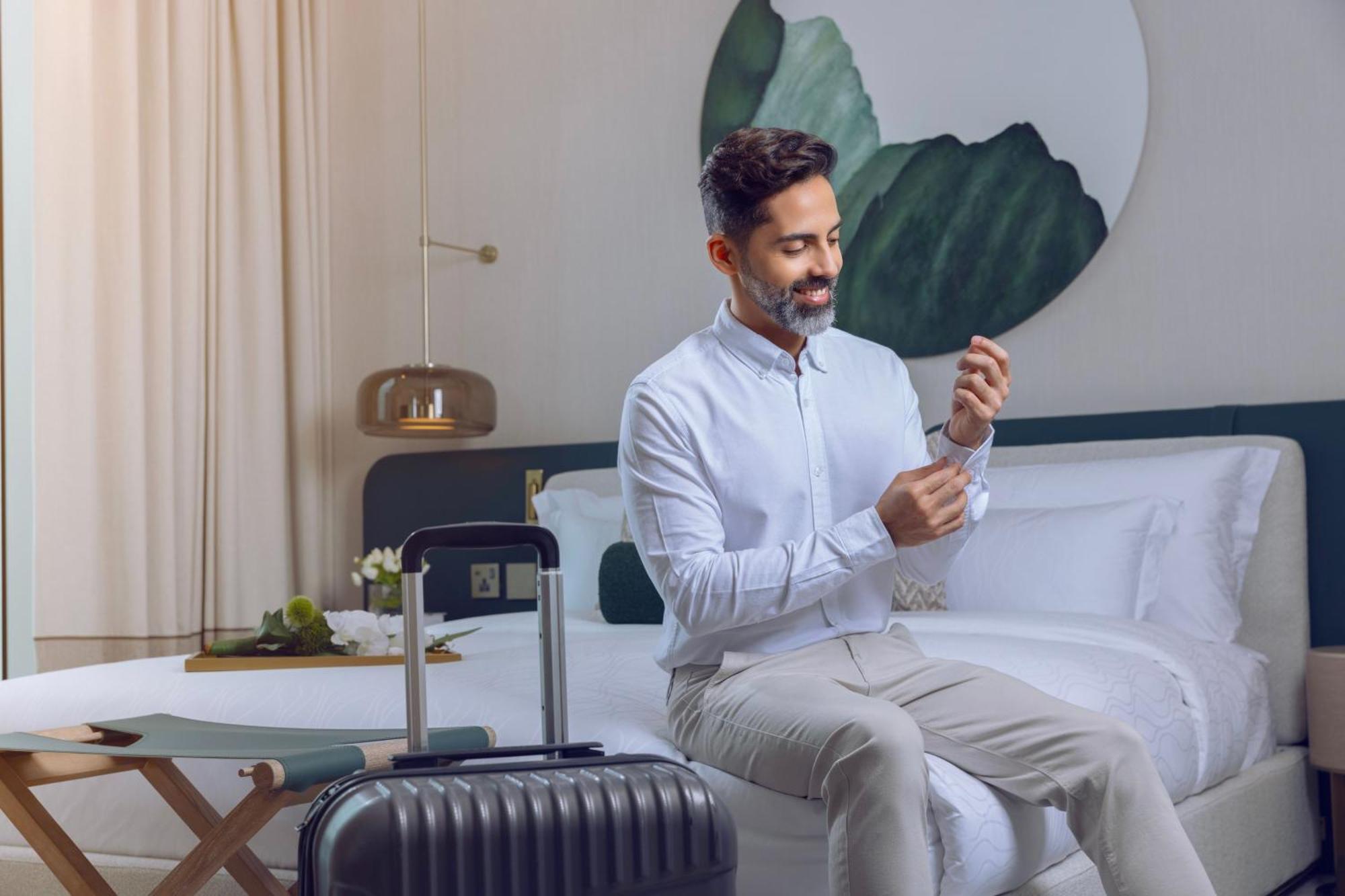 מלון מנאמה Onyx Rotana מראה חיצוני תמונה A man using a mobile phone